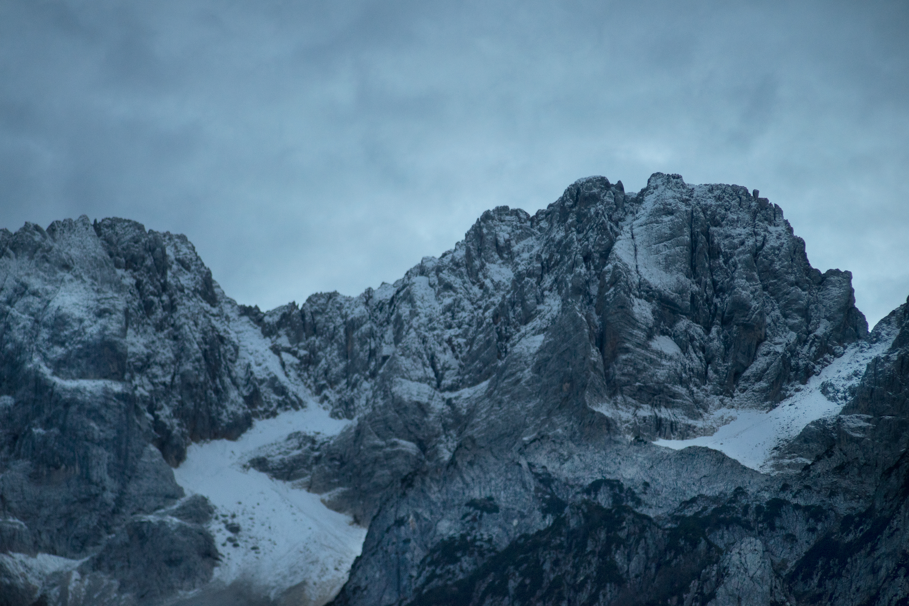 A gray and blue image of a mountain with a sky background. Creative Commons