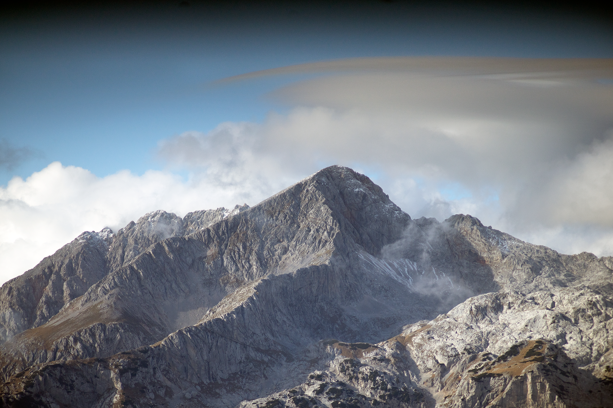 A pretty gray image of a mountain and a blue sky. Creative Commons